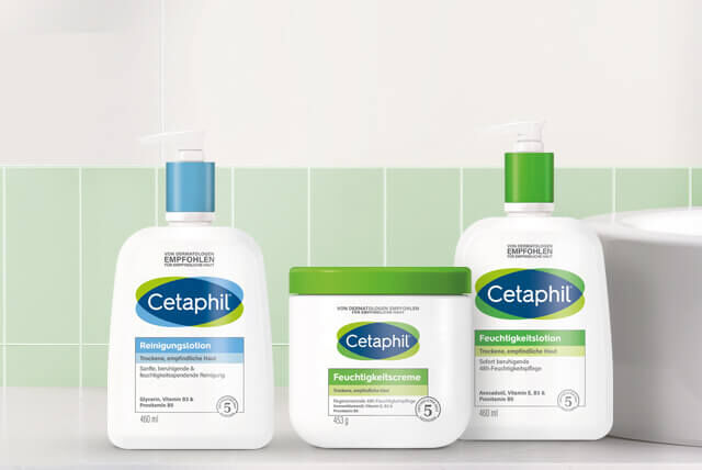 Drei Cetaphil Hautpflegeprodukte aus der Basispflege-Serie vor grün gekachelter Wand